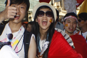 Pilgrims from Hong Kong, China, cheer as they walk to the Opening Mass of World Youth Day in the center of Madrid.